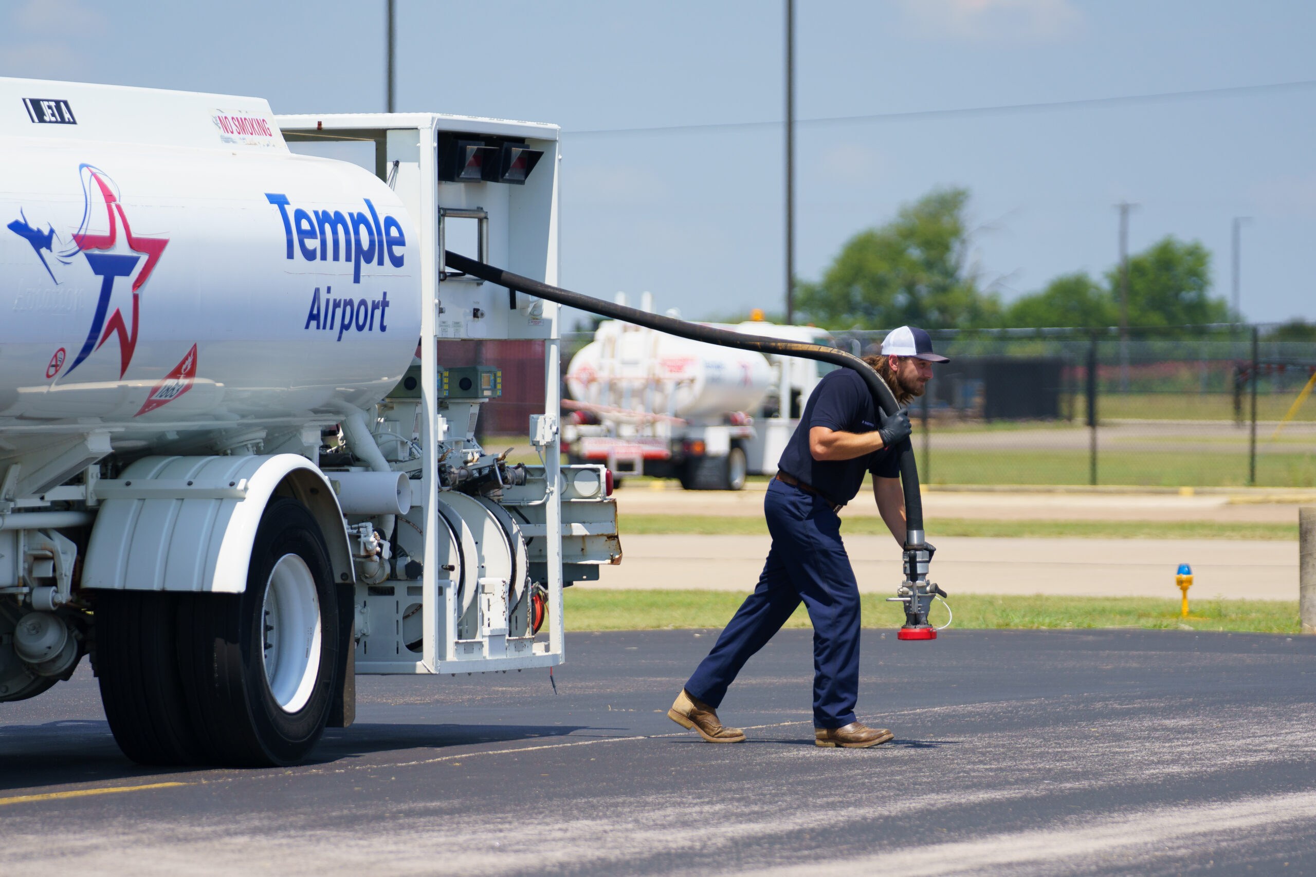 workers pulling a full line from a fuel tankser at Dragon-Miller Regional Airport in Temple Texas