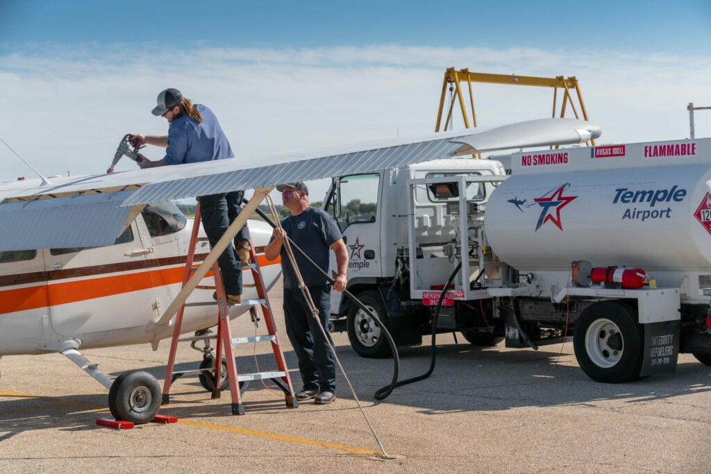 workers woking on an airplane at Dragon-Miller Regional Airport in Temple Texas